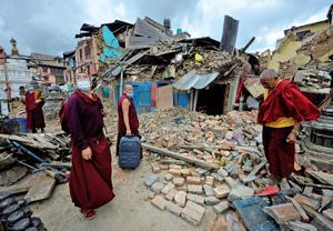 Monaci buddisti accanto al tempio distrutto